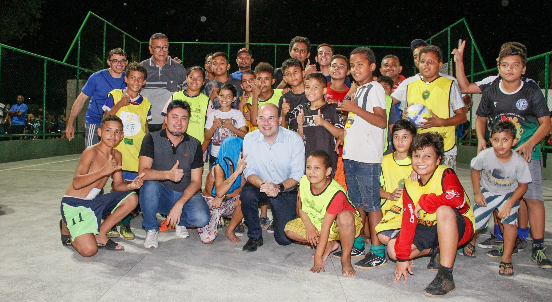 prefeito posa com grupo de garotos numa quadra esportiva